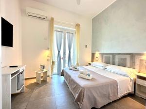 a bedroom with a large bed and a television at Hotel Marconi in Sperlonga