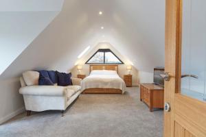 a attic bedroom with a bed and a couch at The Lodge Bury St Edmunds in Bury Saint Edmunds