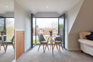 a dining room with a table and chairs in a house at The Lodge Bury St Edmunds in Bury Saint Edmunds +8 photos