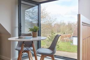 a table and two chairs in front of a window at The Lodge Bury St Edmunds in Bury Saint Edmunds