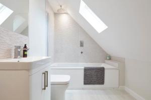 a white bathroom with a sink and a toilet at The Lodge Bury St Edmunds in Bury Saint Edmunds