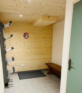 Habitación con pared de madera y banco. en Appartement les Clochettes 1 - Pied des pistes, en Les Deux Alpes