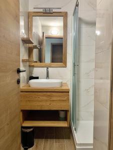 uma casa de banho com um lavatório e um espelho em Olimian Oasis Village Lipa 107 em Podcetrtek