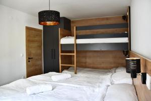 a bedroom with a bed with two bunk beds at Olimian Oasis Village Lipa 107 in Podčetrtek