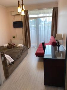 第比利斯Siqvaruli的一间带床、沙发和窗户的卧室