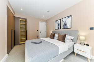 a bedroom with a large white bed and a night stand at North Kensington - Portobello by Viridian Apartments in London