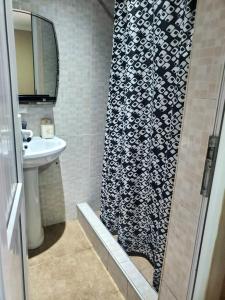 y baño con cortina de ducha y lavamanos. en Guest house Agmashenebeli 229 en Kobuleti