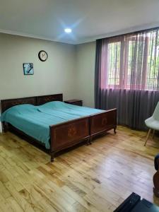1 dormitorio con 1 cama y reloj en la pared en Guest house Agmashenebeli 229 en Kobuleti