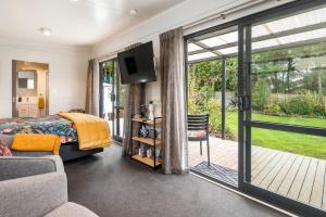 1 dormitorio con 1 cama y puerta corredera de cristal en Birdsong - Turangi Holiday Unit en Turangi
