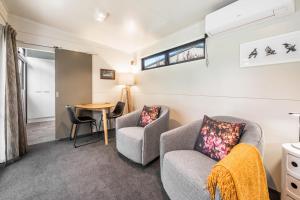 a living room with two chairs and a table at Birdsong - Turangi Holiday Unit in Turangi
