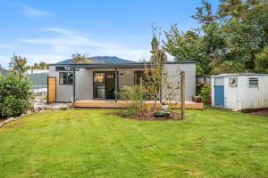 a small house with a lawn in front of it at Birdsong - Turangi Holiday Unit in Turangi