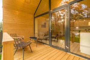 a screened in deck with chairs and a table at Bursztynowo in Kąty Rybackie