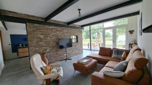 a living room with couches and a brick wall at Woning in Born in Born