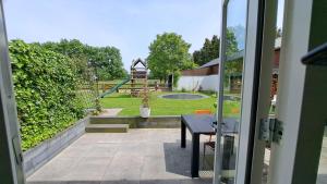a sliding glass door to a patio with a playground at Woning in Born in Born
