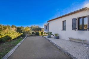 une maison blanche avec un banc à côté dans l'établissement L'élixir - Architect villa & Heart of Provence, à Flayosc