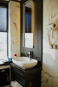 a bathroom with a white sink and a mirror at QUALA Hotels in Aksaray