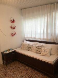 Bett in einem Zimmer mit Fenster und Kissen in der Unterkunft Summer beach house Spiaggia in Katarrákhion