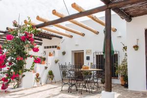 a patio with a table and chairs and flowers at Villa AURORA Nijar in Níjar
