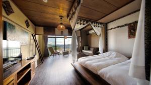 Bali Resort SAYA no Kaze في توبا: غرفة نوم فيها سرير وتلفزيون