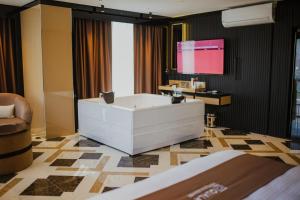a bathroom with a tub and a tv on the wall at QUALA Hotels in Aksaray