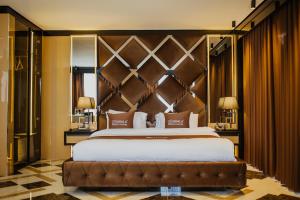 a bedroom with a large bed with a large headboard at QUALA Hotels in Aksaray