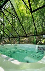 eine Whirlpool-Badewanne in einem Zelt mit Bäumen im Hintergrund in der Unterkunft Montebello Chalet in Porumbacu de Sus