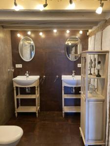 a bathroom with two sinks and two mirrors at Les Ordalies in Castelnaudary