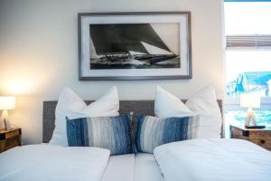ein weißes Bett mit Kissen und einem Bild an der Wand in der Unterkunft Koje No1 in Kappeln