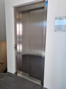 einen Aufzug in einem Gebäude mit einer Metalltür in der Unterkunft Koje No1 in Kappeln
