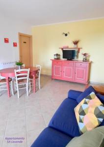 ein Wohnzimmer mit einem Sofa und einem Tisch in der Unterkunft I fiori di Alberese in Alberese