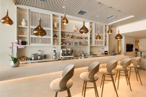 a bar with a row of chairs in a room at Holiday Inn Thessaloniki, an IHG Hotel in Thessaloniki