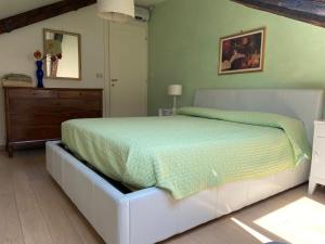 1 dormitorio con cama blanca y edredón verde en Casa Tella en Venecia