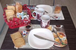 a table with plates and sandwiches and a basket of food at Casa Stadio - Parco Dora in Turin