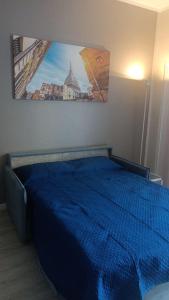 a bedroom with a blue bed with a picture on the wall at Casa Stadio - Parco Dora in Turin