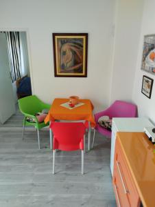 una sala da pranzo con tavolo e sedie colorate di Cyclo Apartment Pinki a Bačka Palanka