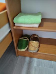una mensola con due asciugamani e un paio di scarpe di Cyclo Apartment Pinki a Bačka Palanka