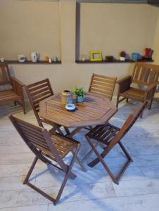 een houten tafel met twee stoelen en een tafel met een plant bij Cyclo Apartment Pinki in Bačka Palanka
