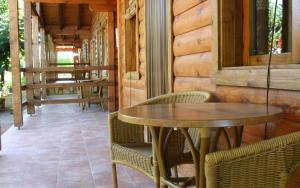 un patio con 2 mesas y sillas en un porche en Casas de Madera Los Molinos, en Ossa de Montiel