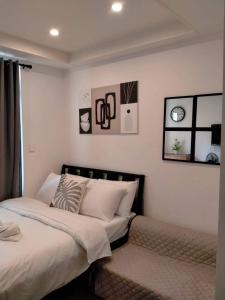 1 dormitorio con 1 cama y algunas fotos en la pared en Megatower Residence shortwalk2 SM BAGUIO BURNHAM, en Baguio