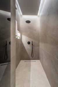 a bathroom with a walk in shower in a room at ICONIC SALONICA SUITES seafront in Thessaloniki +61 photos