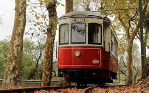 a red and white trolley car on the tracks at Alto da Praia Villa in Colares