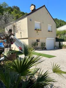 ein großes Haus mit Garage und einigen Pflanzen in der Unterkunft Maison de campagne entre vigne et bois in Chablis