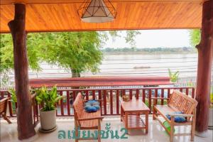 a porch with a table and chairs and a view of the water at สุขนิรันดร์​ริมโขง in Chiang Khan