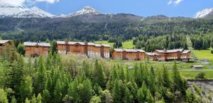 um resort nas montanhas com montanhas ao fundo em Chalet L'arcelle, Spa privée em Lanslebourg-Mont-Cenis
