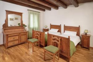 a bedroom with two beds and a vanity and a mirror at Agriturismo Rechsteiner in Ponte di Piave