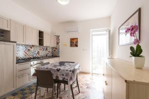 eine Küche mit einem Tisch und einigen Stühlen und einem Tisch sowie eine Küche mit in der Unterkunft Casa Blu in Castellammare del Golfo