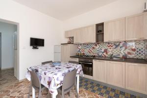 eine Küche mit einem Tisch und einem Tischtuch darauf in der Unterkunft Casa Blu in Castellammare del Golfo