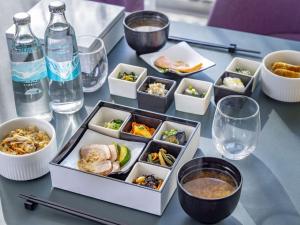 a table with bowls of food and bottles of water at Tokyu Stay Nihombashi in Tokyo