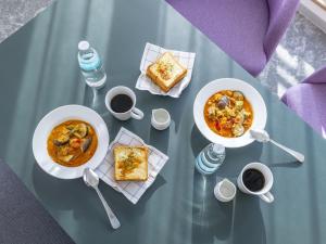 a table with two bowls of soup and some food at Tokyu Stay Nihombashi - Tokyo in Tokyo