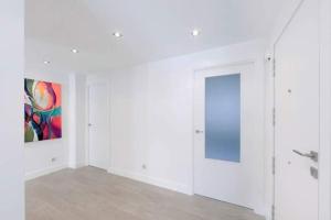 ein Zimmer mit weißen Wänden und einem Gemälde an der Wand in der Unterkunft Acogedor y precioso apartamento + parking privado in San Sebastián